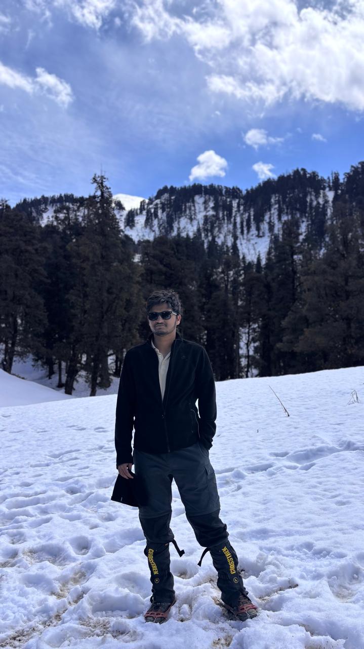 Standing on a snow field below a pine ridge in the Himalayas
